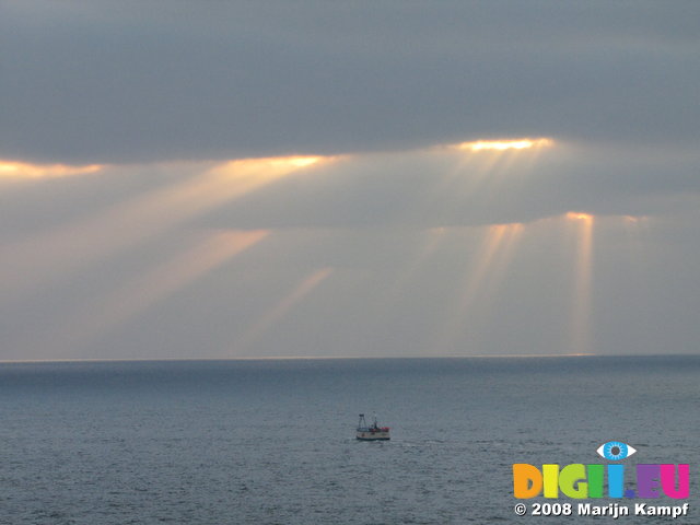 SX01274 Sunrays over small boat on sea